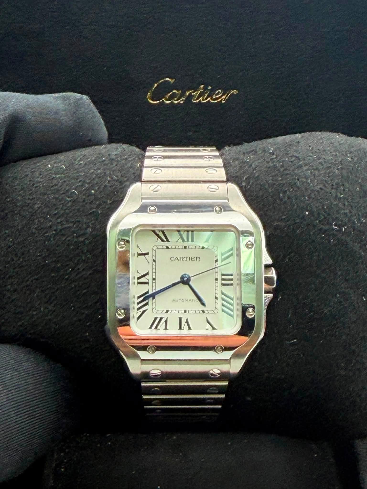 May be an image of wrist watch and text that says 'Cariier Ca riier ® α M XIXII XII I CARTIER a iX 4иTOMAT III F TEIIMNIOY И nИA ٨'