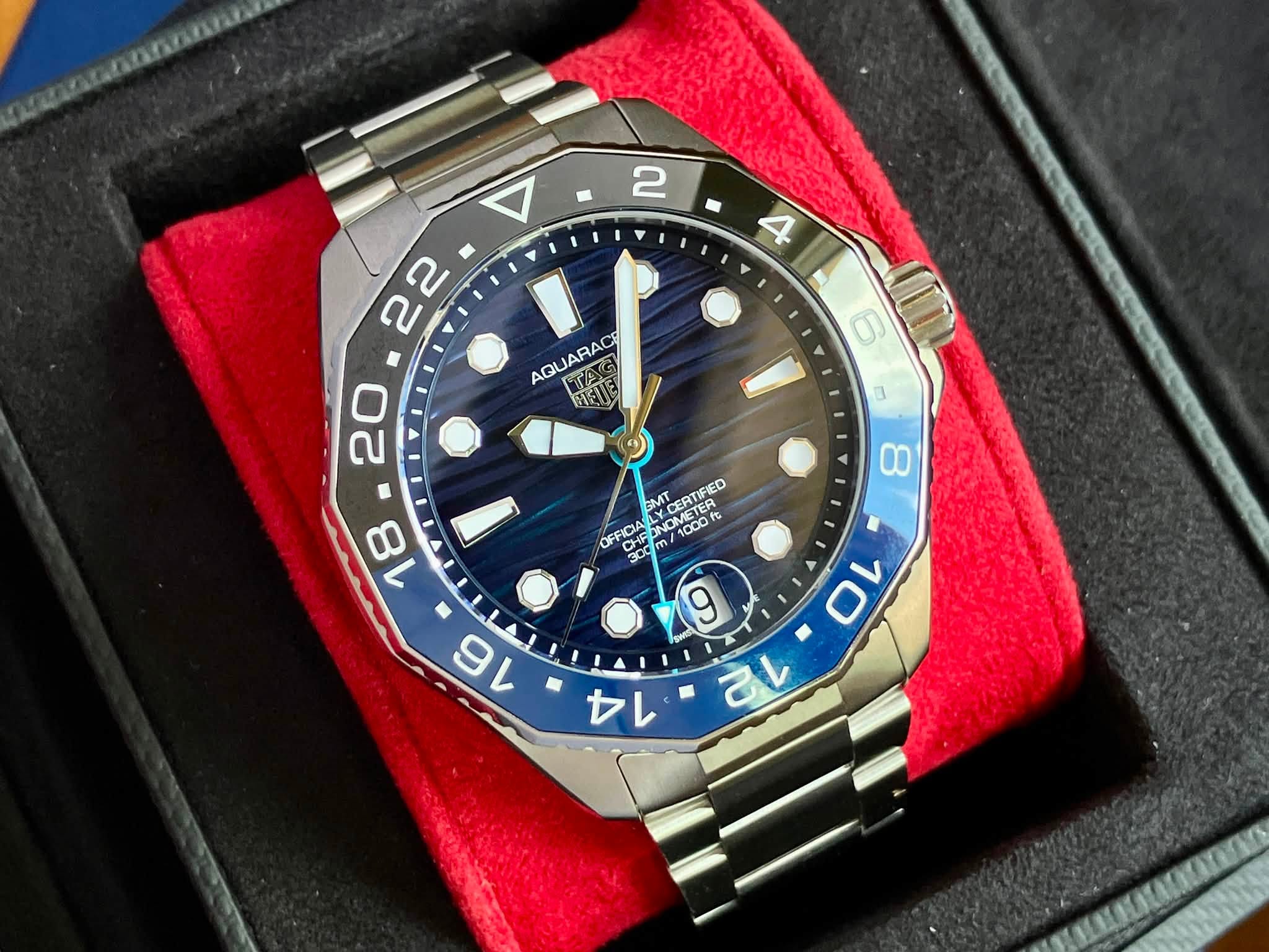 May be an image of wrist watch and text that says ' AQUARAC TAS NKIE 6 m 8 18 GMT OMETER EATIFED OFFICIA ONON ETER CERIPEL 1000 000 CHEI 30d m/ '