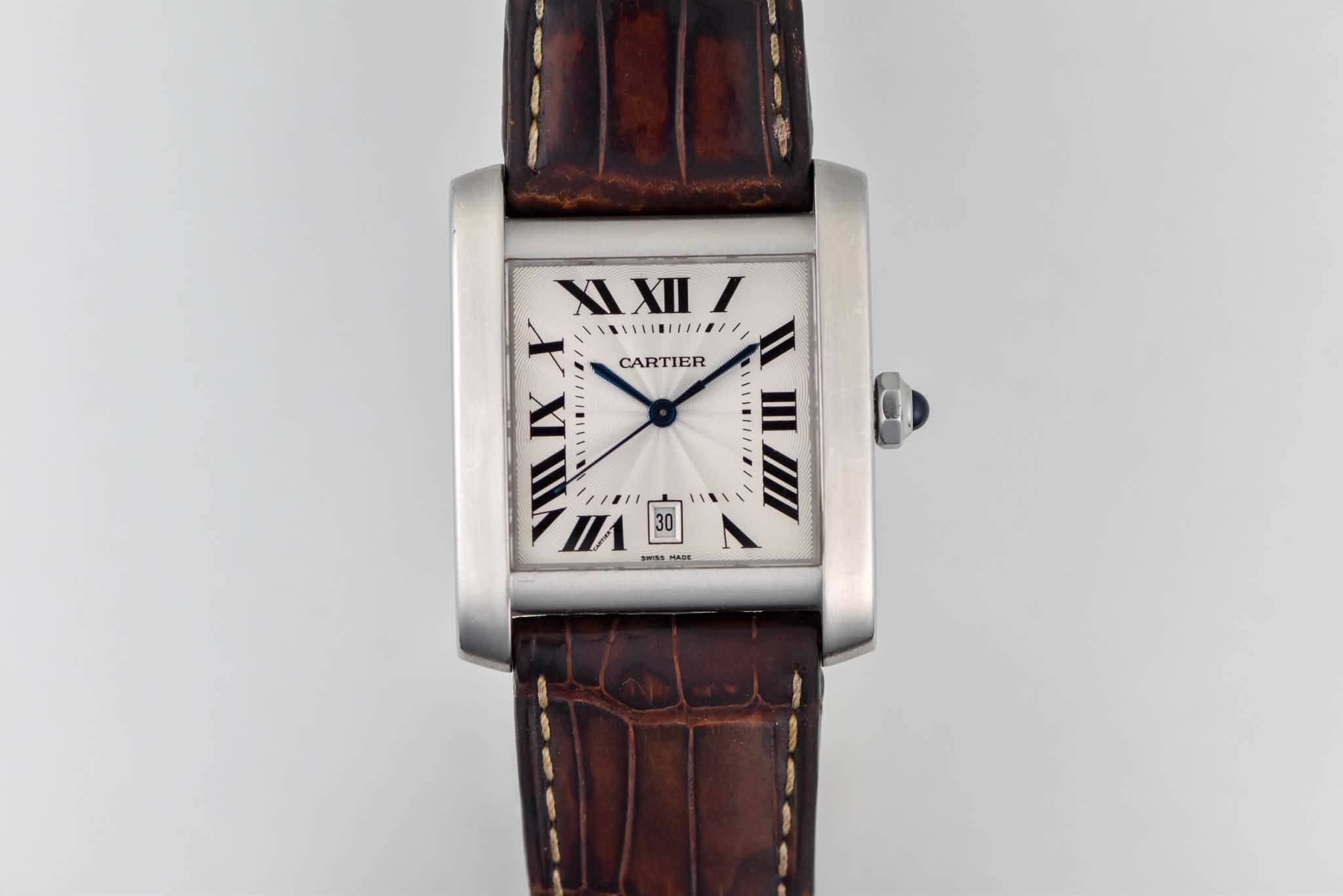May be an image of wrist watch and text that says 'XIXIII XI XII I 十 ////////////// CARTIER VILIX ΠΑ /'