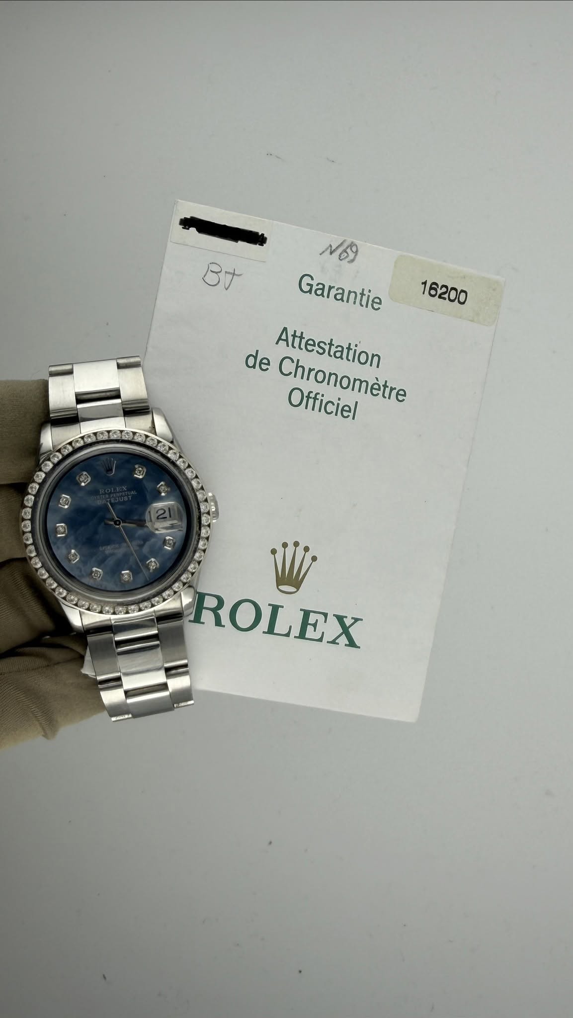 May be an image of wrist watch and text that says 'B寸 16200 N69 Garantie de Chronomètre Officiel Attestation ROLEX'