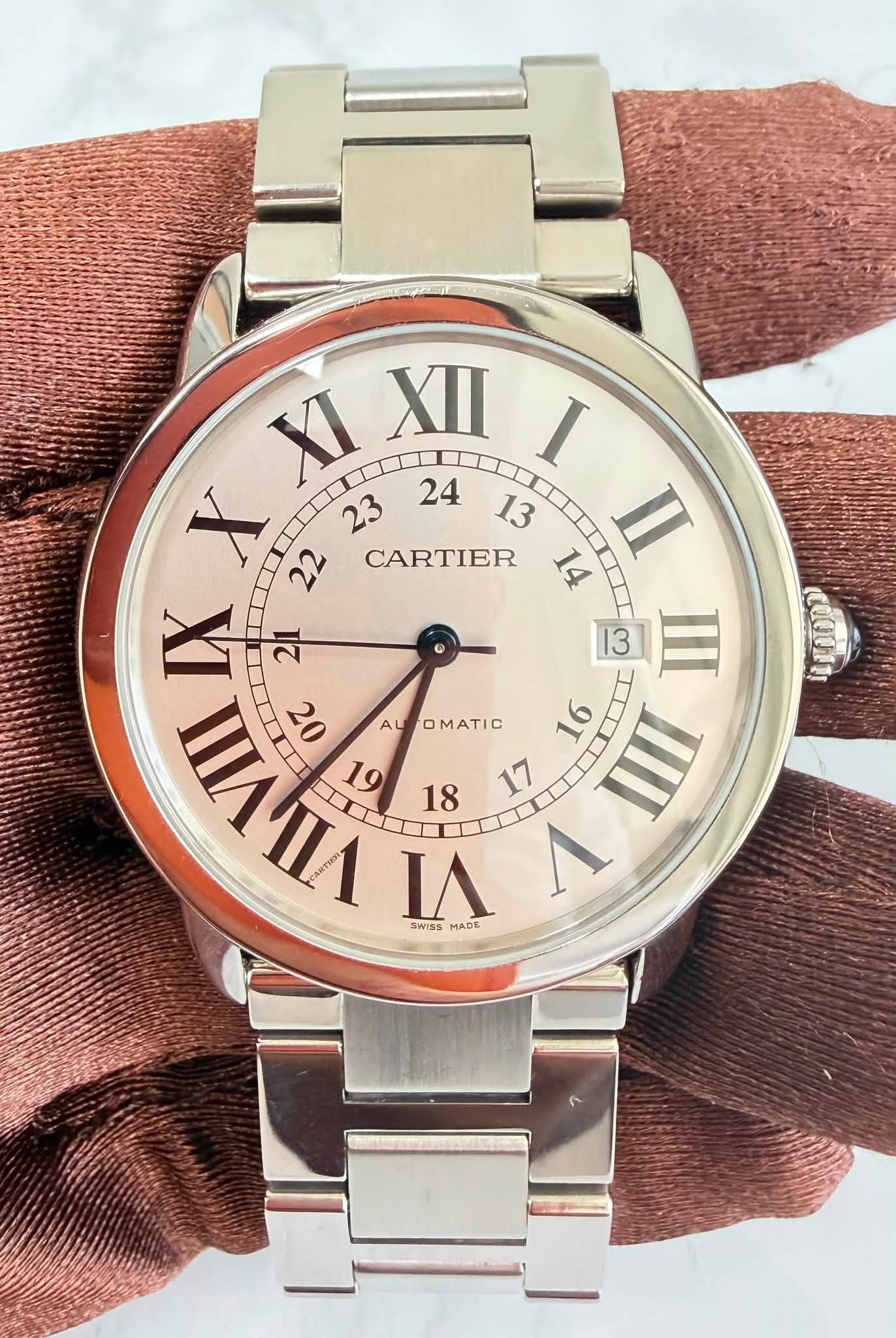 May be an image of wrist watch and text that says 'XI XII I X 22 CARTIER 14 II 23 24 13 IX 21 13 III ンも AU ALTOMATIC nИnA SmSS MADE VIIII 22 OMATIC S 1 (LI0DO)'