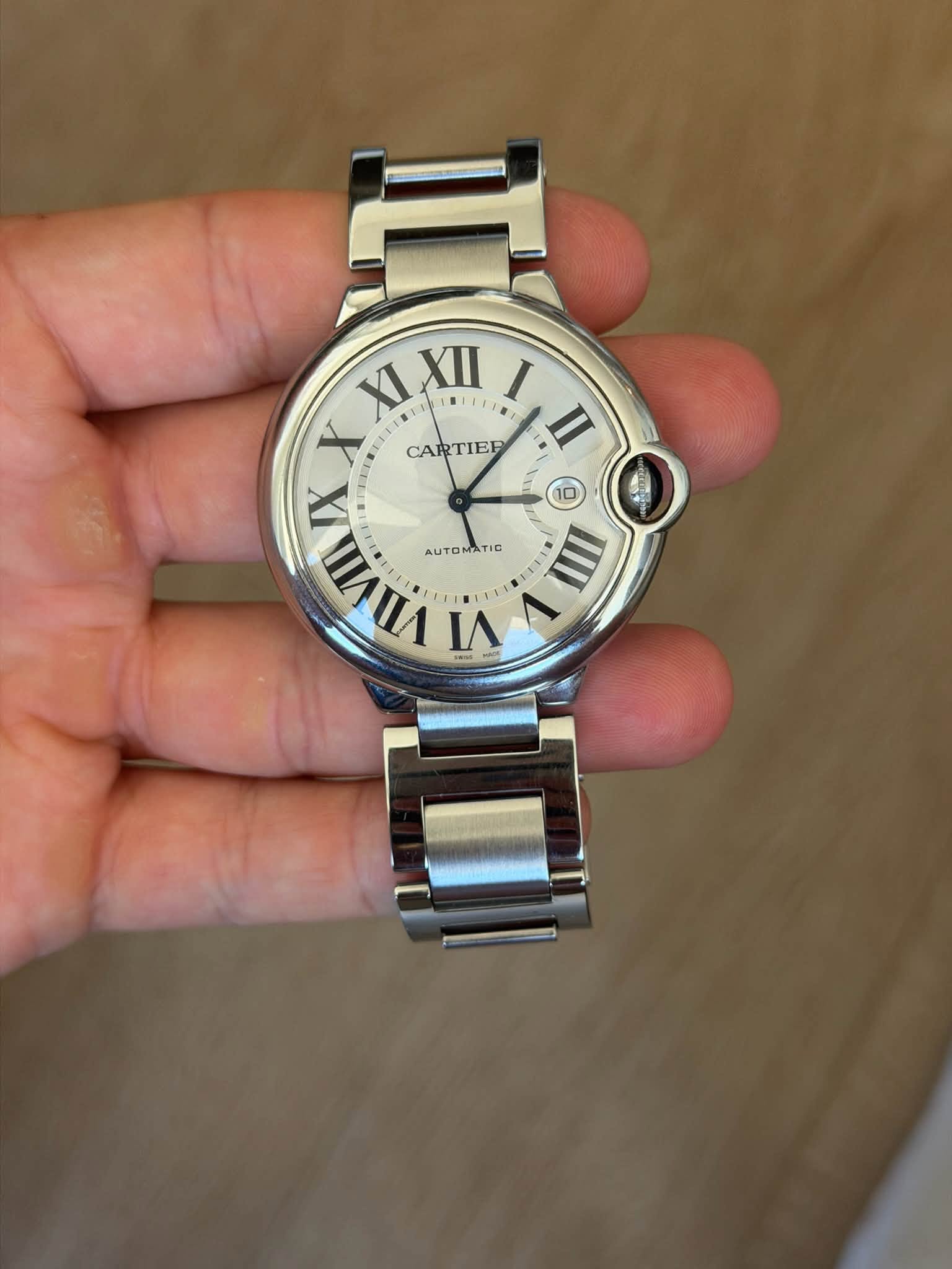 May be an image of wrist watch and text that says 'XI XLXII 川如! LIFTB I X CARTIER II VIVII V X AUTO AUTOMATIC TIC IIII VI VI'