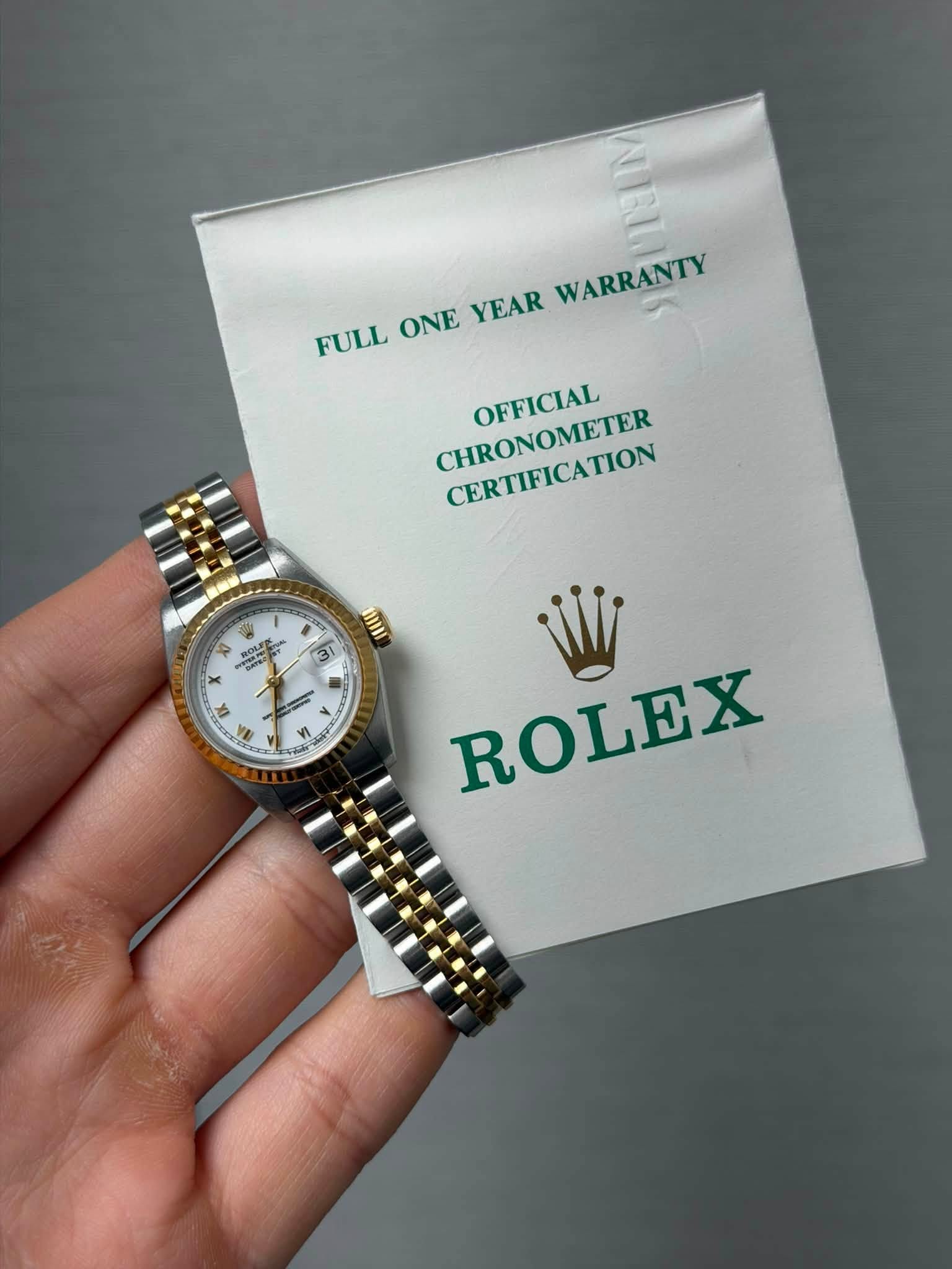 May be an image of wrist watch and text that says 'FULL FULL ONE YEAR WARRANTY CHRONOMETER CERTIFICATION CERTIFICATION OFFICIAL 1 ៣ က ក ROLI ROU つ + X ۸ EX I N 1A 1 - > 4 ប្ 2…