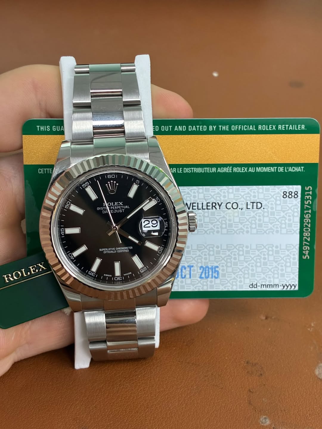 May be an image of wrist watch and text that says 'THIS GUA ED OUT AND DATED BY THE OFFICIAL ROLEX RETAILER. CETTE 60 35 ARLE DISTRIBUTEUR AGRÉÉ ROLEX IEOSTRUTEURAGTEREXAUMONITE AU…