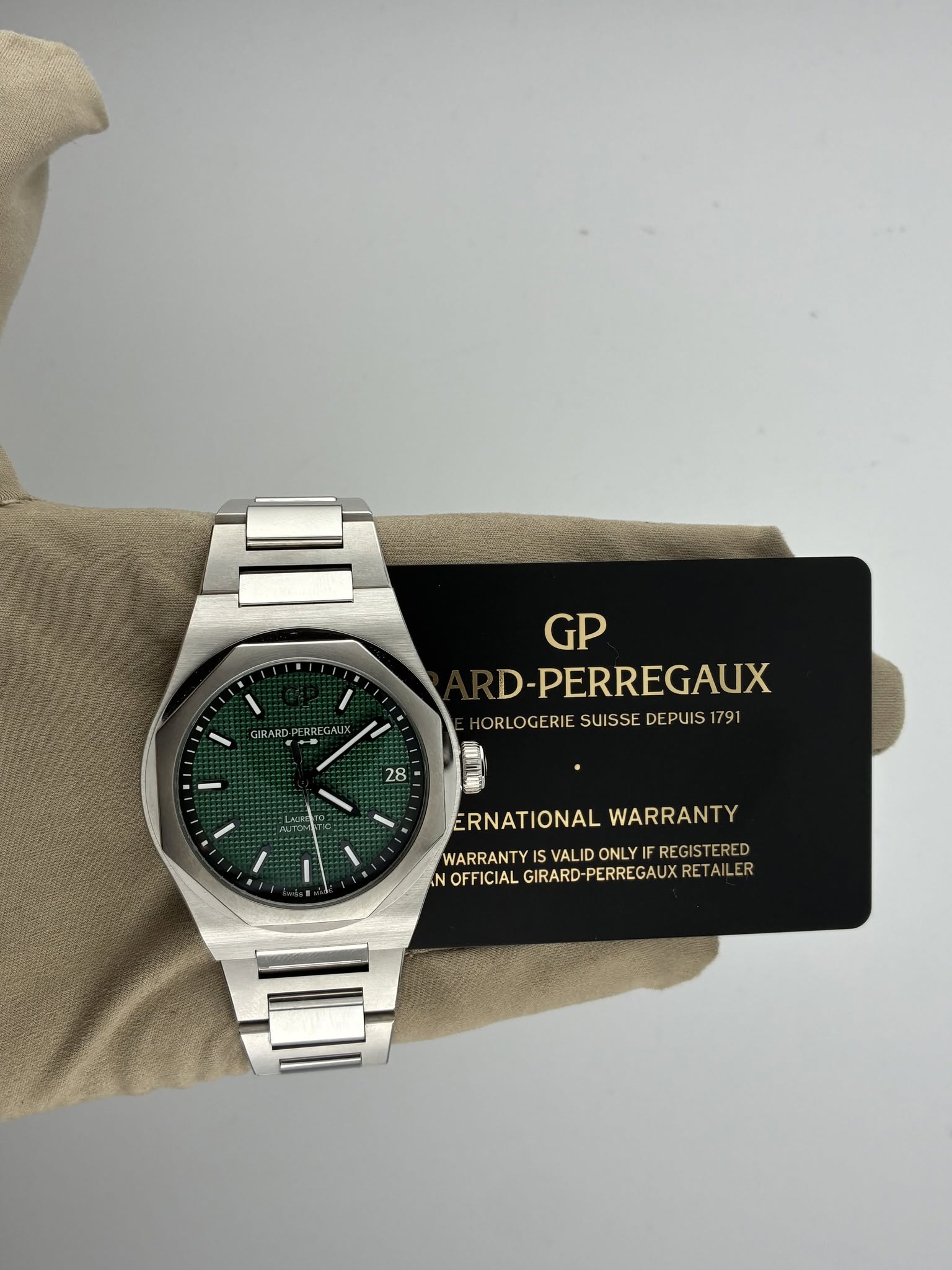 May be an image of wrist watch and text that says 'GIRARD ERRE ALIX GP D-PERREGAUX ORLOGERIE SUISSE DEPUIS ORLOGERIESUISSEDEPUIS179 1791 28 LAU I ERNATIONALWARRANTY ERNATIONAL…