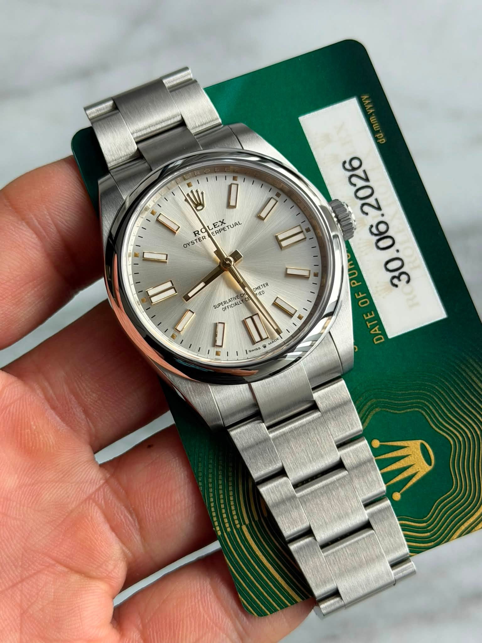 May be an image of wrist watch and text that says 'W I I RO CRPET EX ERPET TUAL OYSTER II サ CHETER UPERLATIE OFFICIALL O p3иuK AA D E M . E DAT DA'