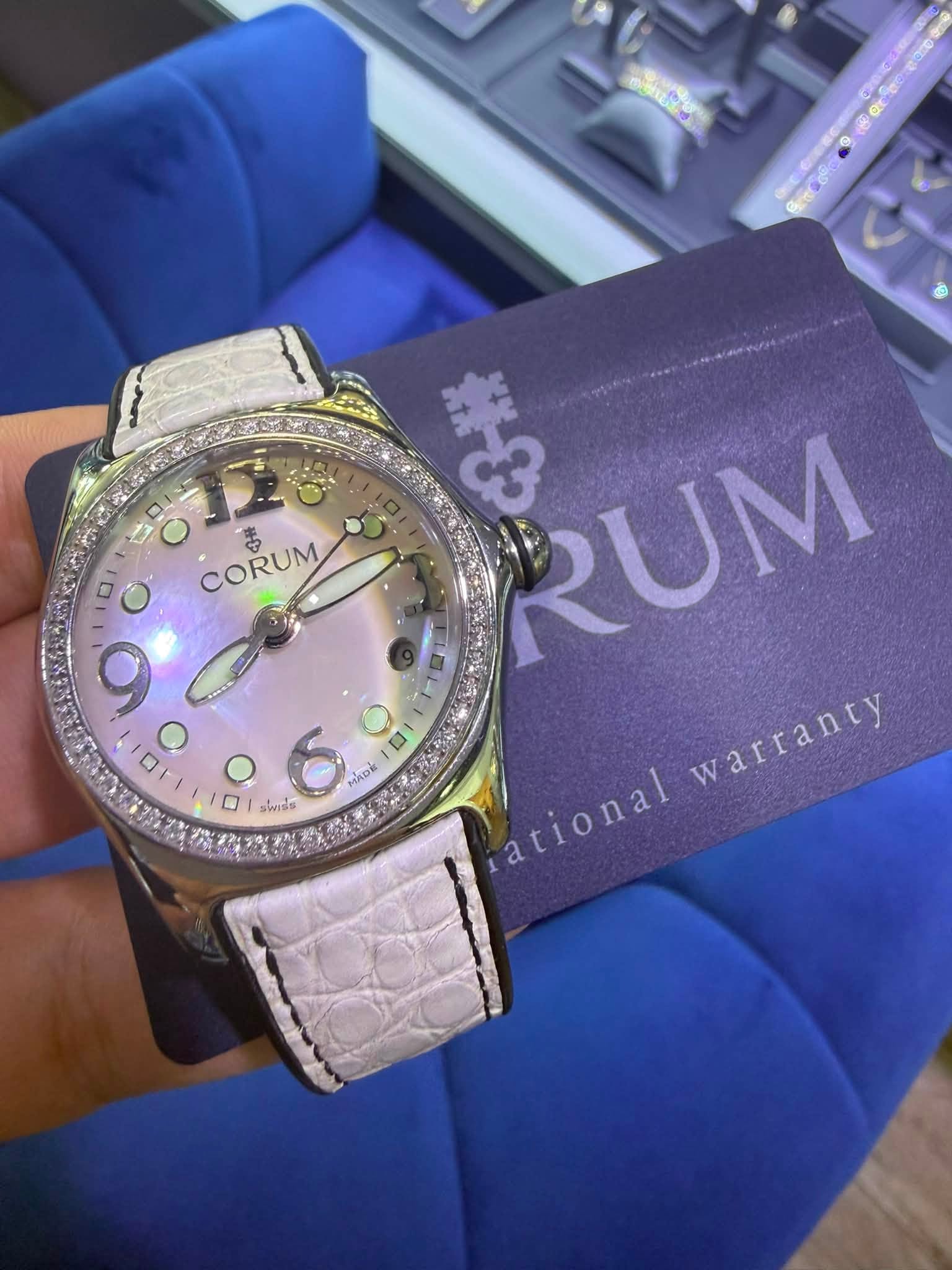 May be an image of wrist watch and text that says 'ال O ٥ CORUM CORUM も O O 口 MADE A 1 swiss PIS RUM warranty warranty fational arional'