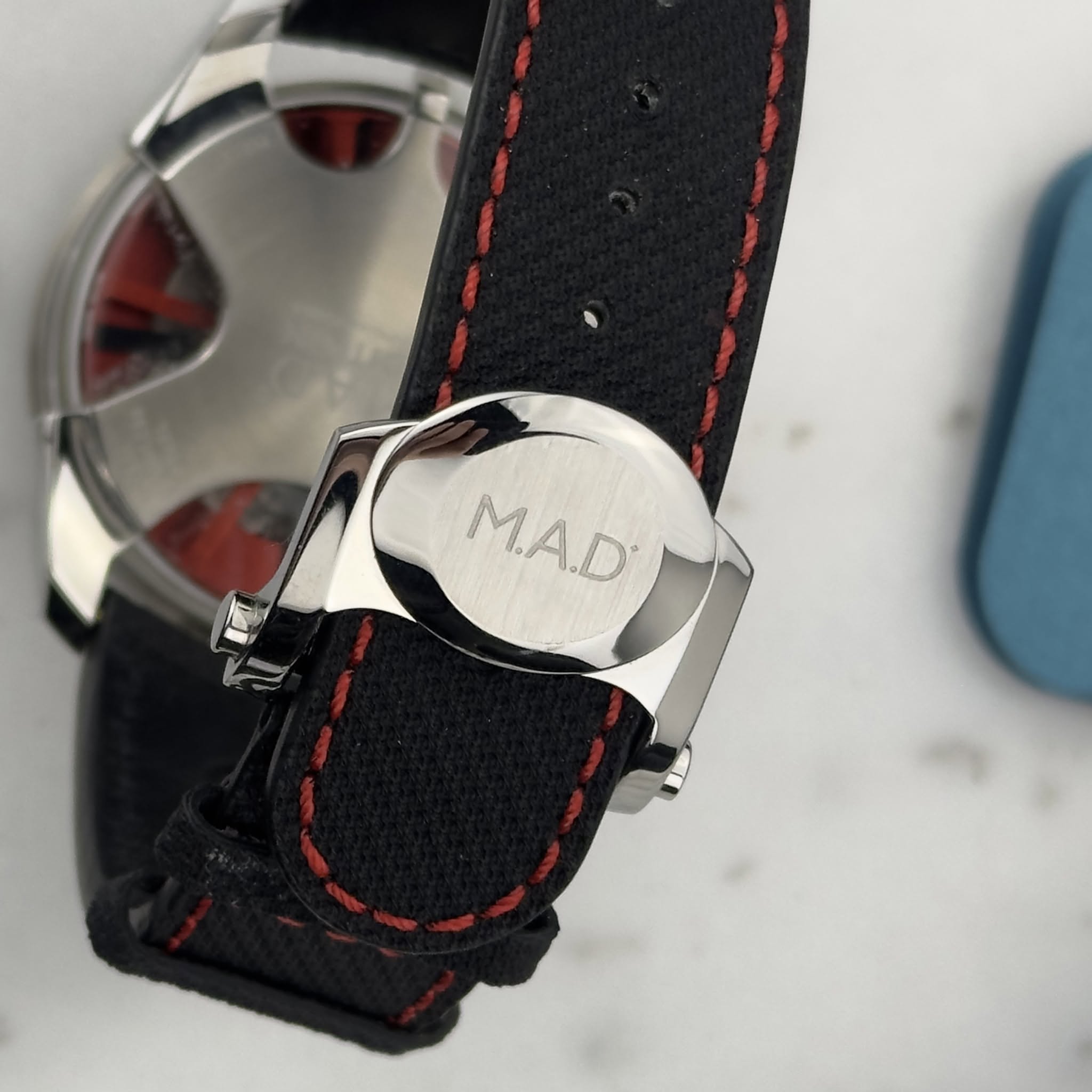 May be an image of wrist watch and text that says '- M.A.D M.A.D T'