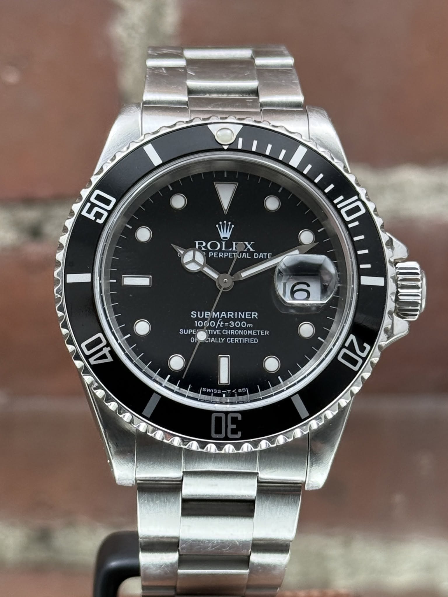 May be an image of wrist watch and text that says '50 10 ROLEX PERPETUAL DATE 6 SUBMARINER 1000ft=300m と=300m 1000ft= SUPE TIVEC CHRONOM HRONOMETER SUPERTTIVECHRONOMETER TER…