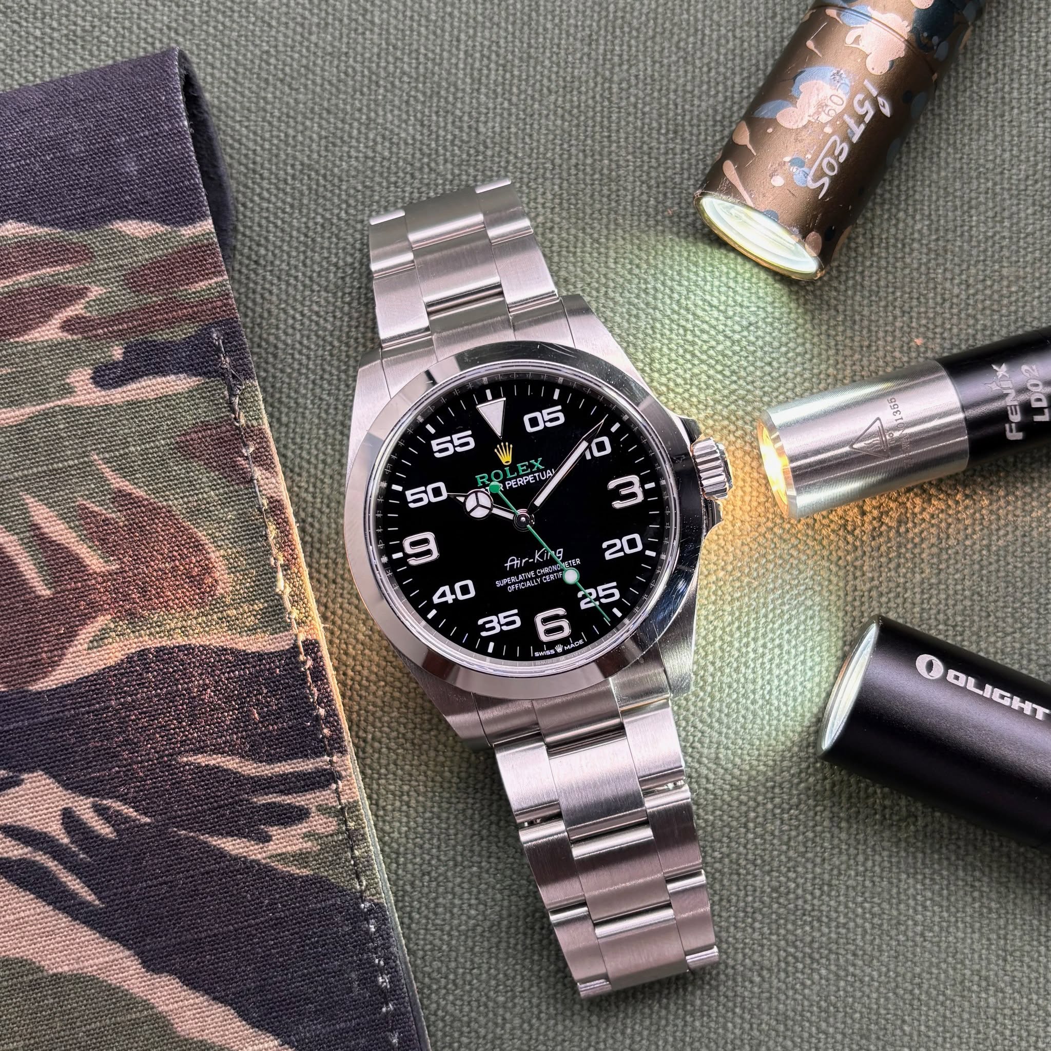 May be an image of wrist watch, lighter and text