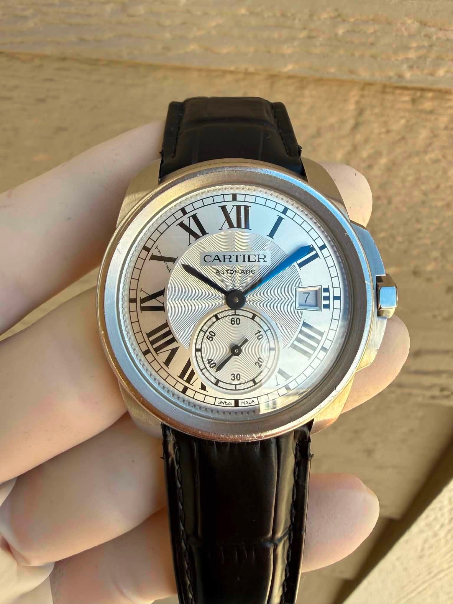 May be an image of wrist watch and text that says 'XI XII I T CARTIER AUTOMATIC I N VIII 50 OV 20 30 SWIS5 MADE'