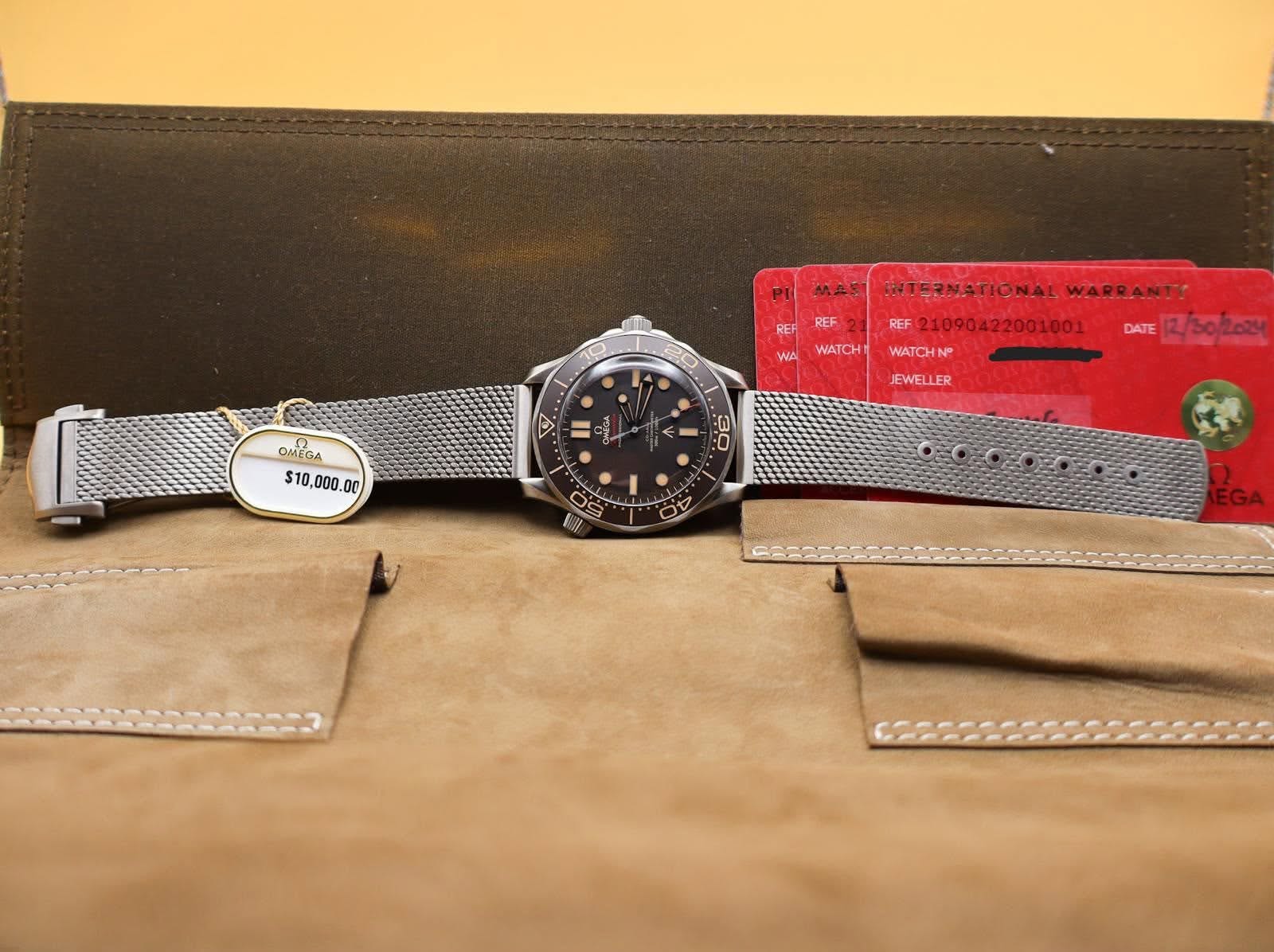 May be an image of wrist watch, leather wallet, saddle-stitched leather, leather and text that says 'PIMAS PI MAS 0 REF REF WA WATCH OMEGA $10 $10,000. ,000 00 . INTERNATIONAL…
