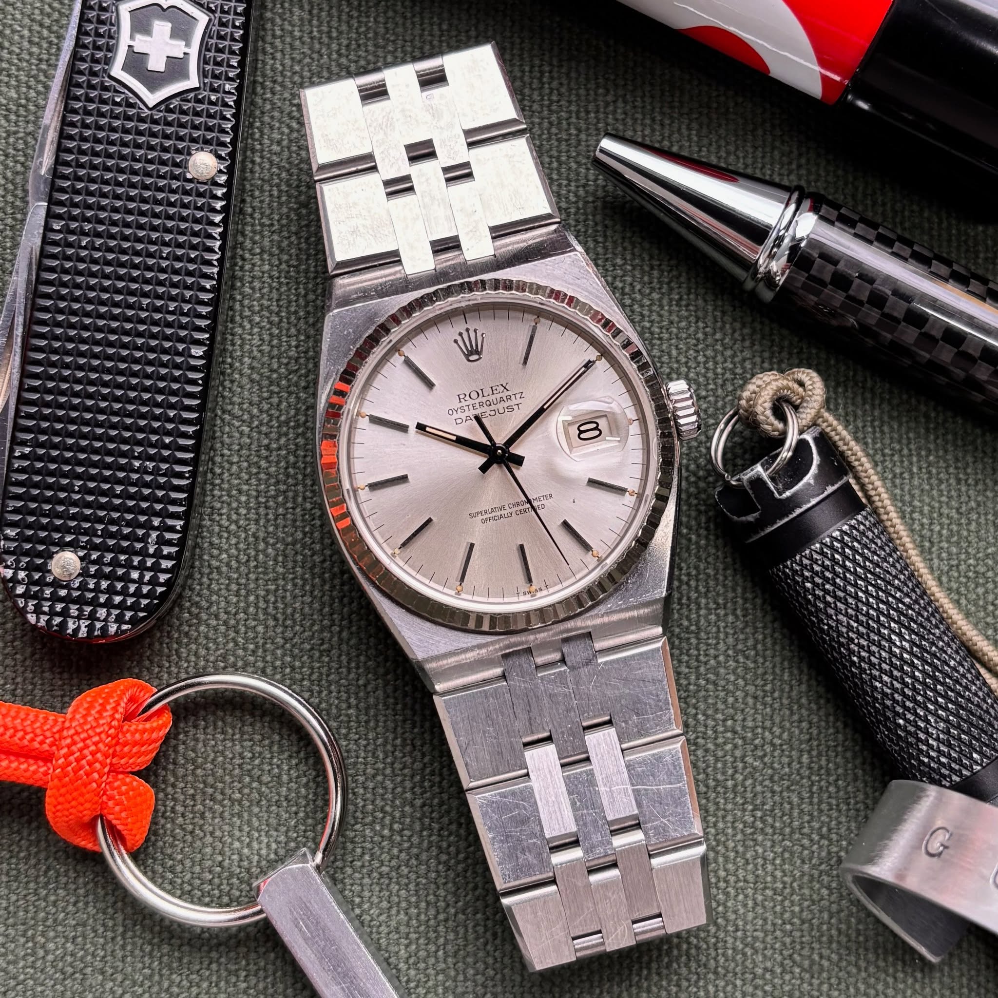 May be an image of knife, lighter, wrist watch and text