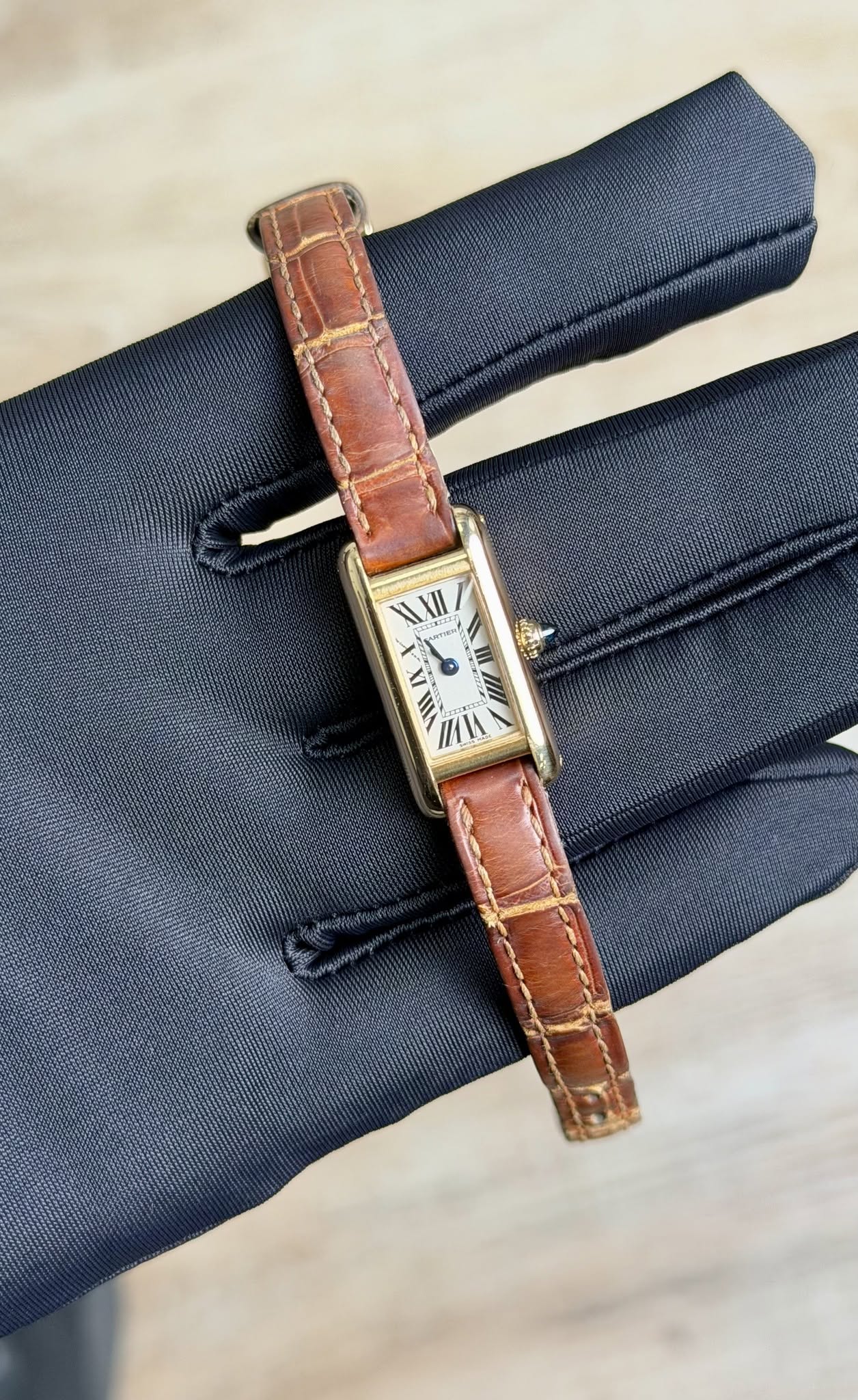 May be an image of saddle-stitched leather, leather, wrist watch and text