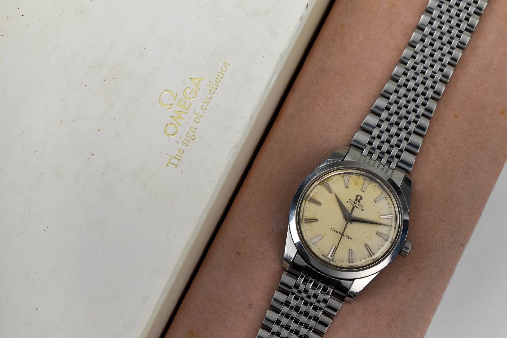 May be an image of wrist watch and text that says 'OMEGA OMECA Thesigaof.excellence of ofexcellence Thesign sign The 0m OMEGA ١ Seam ١ P'