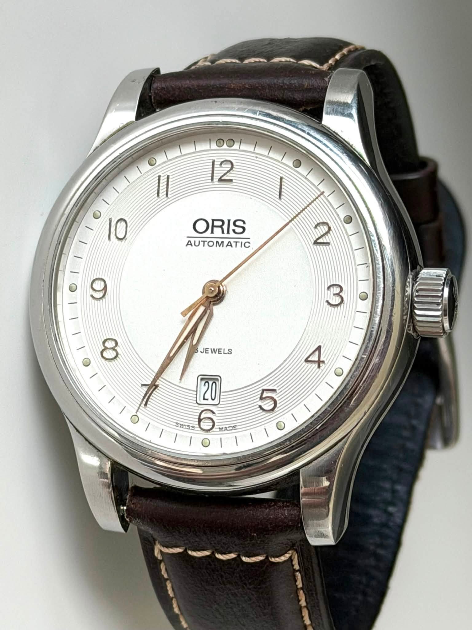 May be an image of wrist watch and text that says '00 12 11 ١ 10 ORIS AUTOMATIC 2 3 8 JEWELS ELS JE 4 20 放生当 6 5 O'
