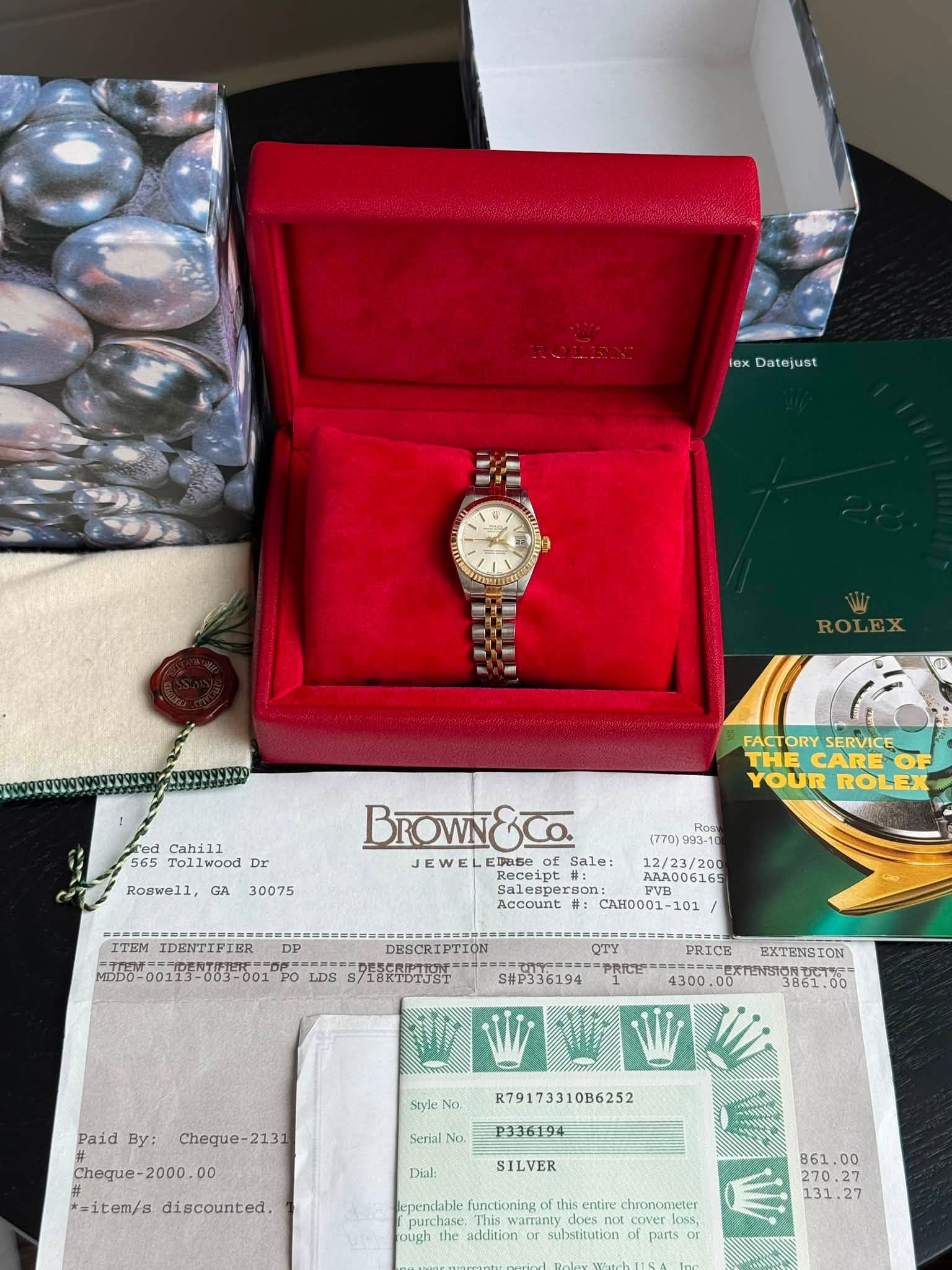 May be an image of wrist watch and text that says 'lex Datejust ROLEX red Cahill 565 Tollwood Dr Roswell, GA FACT ORY SERVICE THE CARE YOUR ROLEX 30075 BROWN ED050 (770) IDENTIPIER…