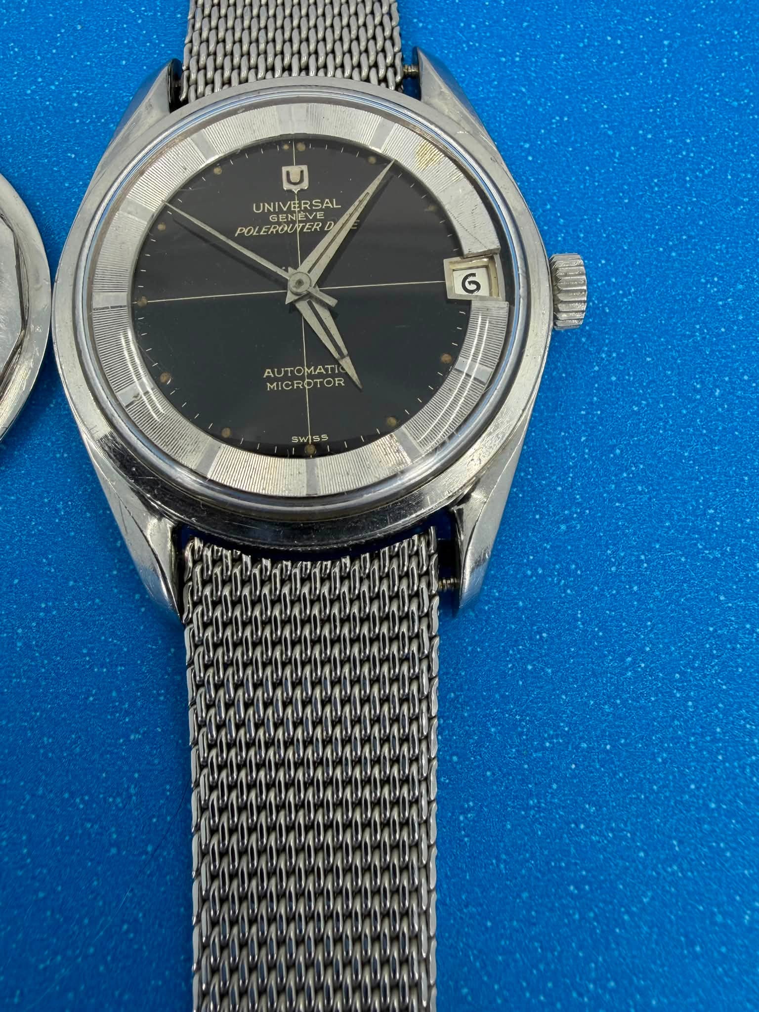 May be an image of wrist watch and text that says 'UNIVERSAL ENEVE UNIVE ERSAL GENEV POL POLEROUTER UTER G AUTOMATI A AUTOMATI MICROT MICROTOR MICROTOR OR ICROT 通白可可的 SwiSs WI'