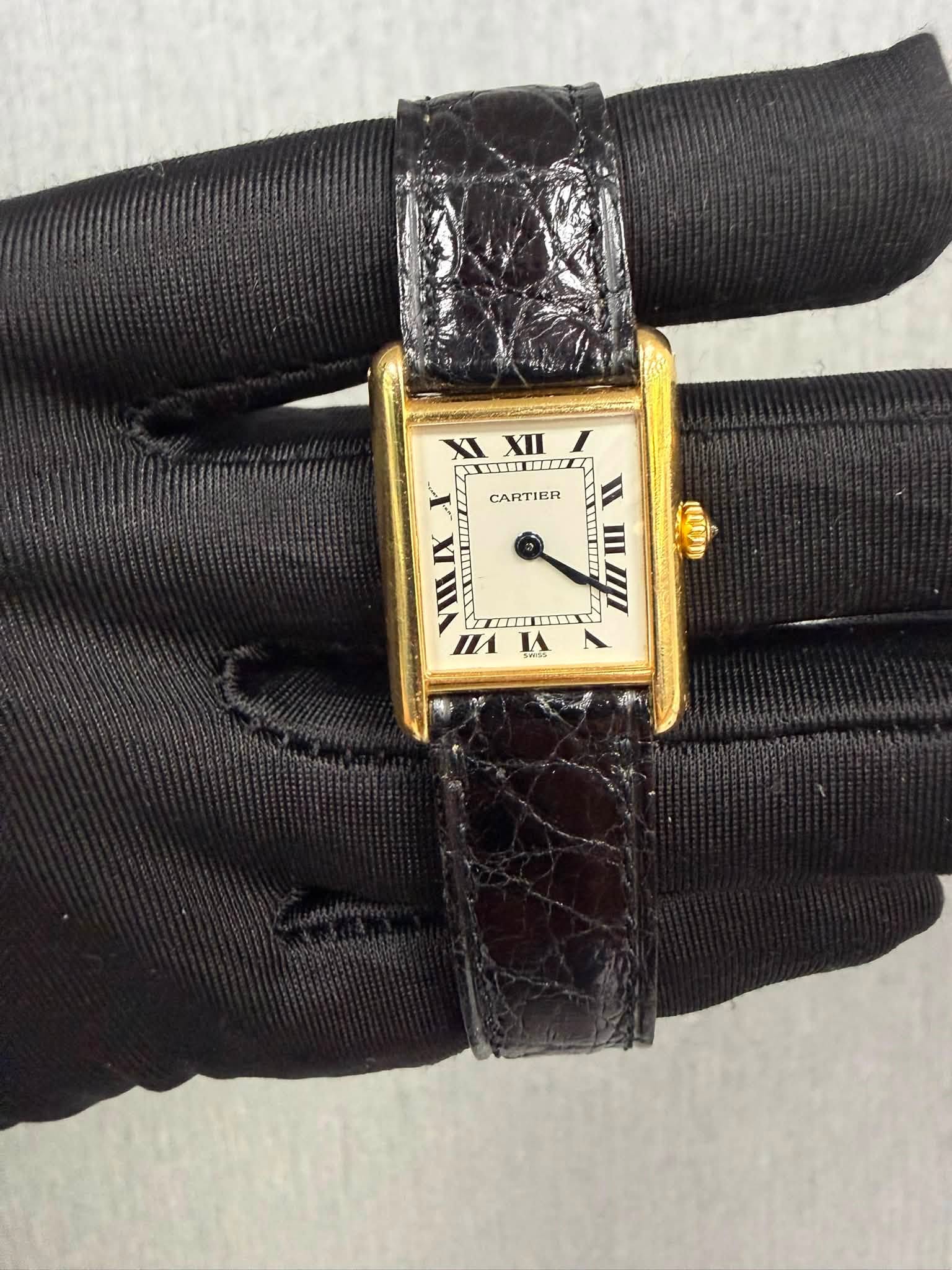 May be an image of wrist watch, leather and text