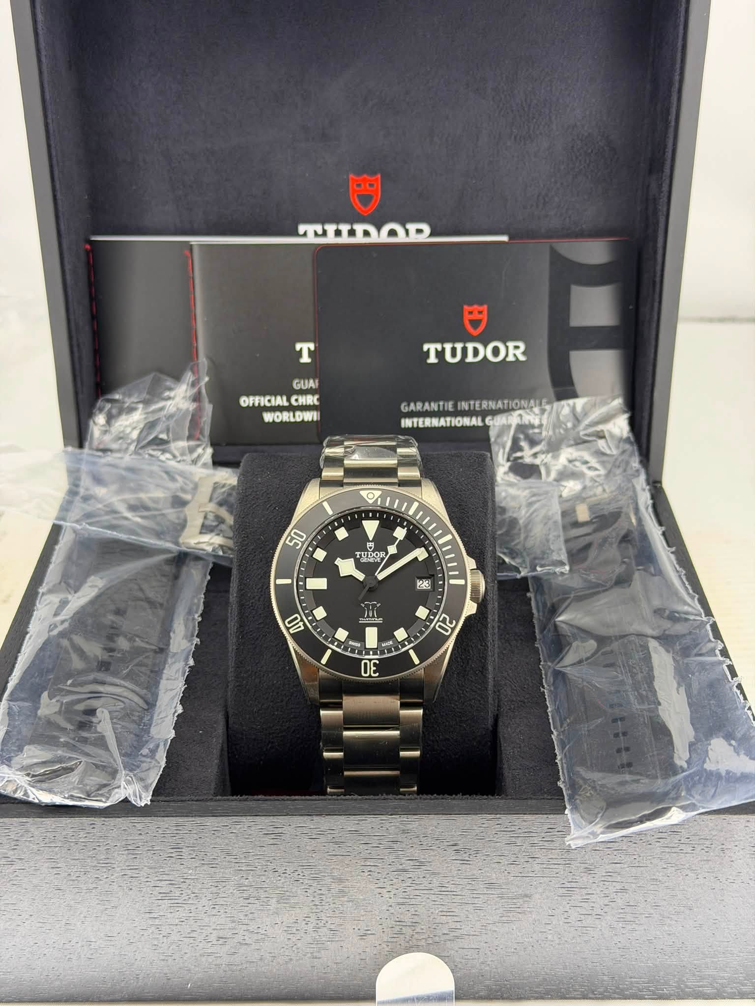 May be an image of wrist watch and text that says '巴 ספחזזטי T 円 TUDOR GUA OFFICIAL CHRC WORLDWII GARANTIEINTERNATIONALE GARANTIE INTERNATIONAIE INTERNATIONAL INTERN O 50 TUDOR…
