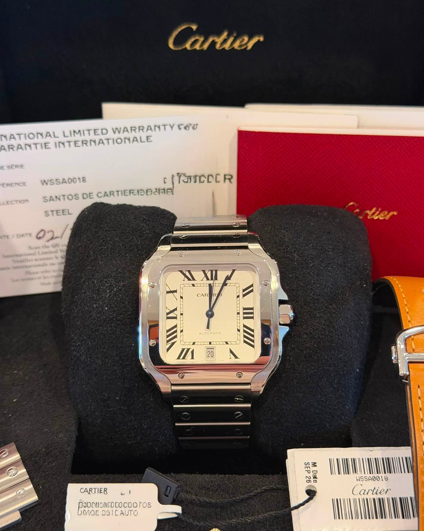 May be an image of wrist watch and text that says 'Cartier YATIONAL LIMITED WARRANTY 06٥ ARANTIE INTERNATIONALE 作作禁使 HENCE LECTION WSSA0018 IY5TCCER R TcCc SANTOS DE…