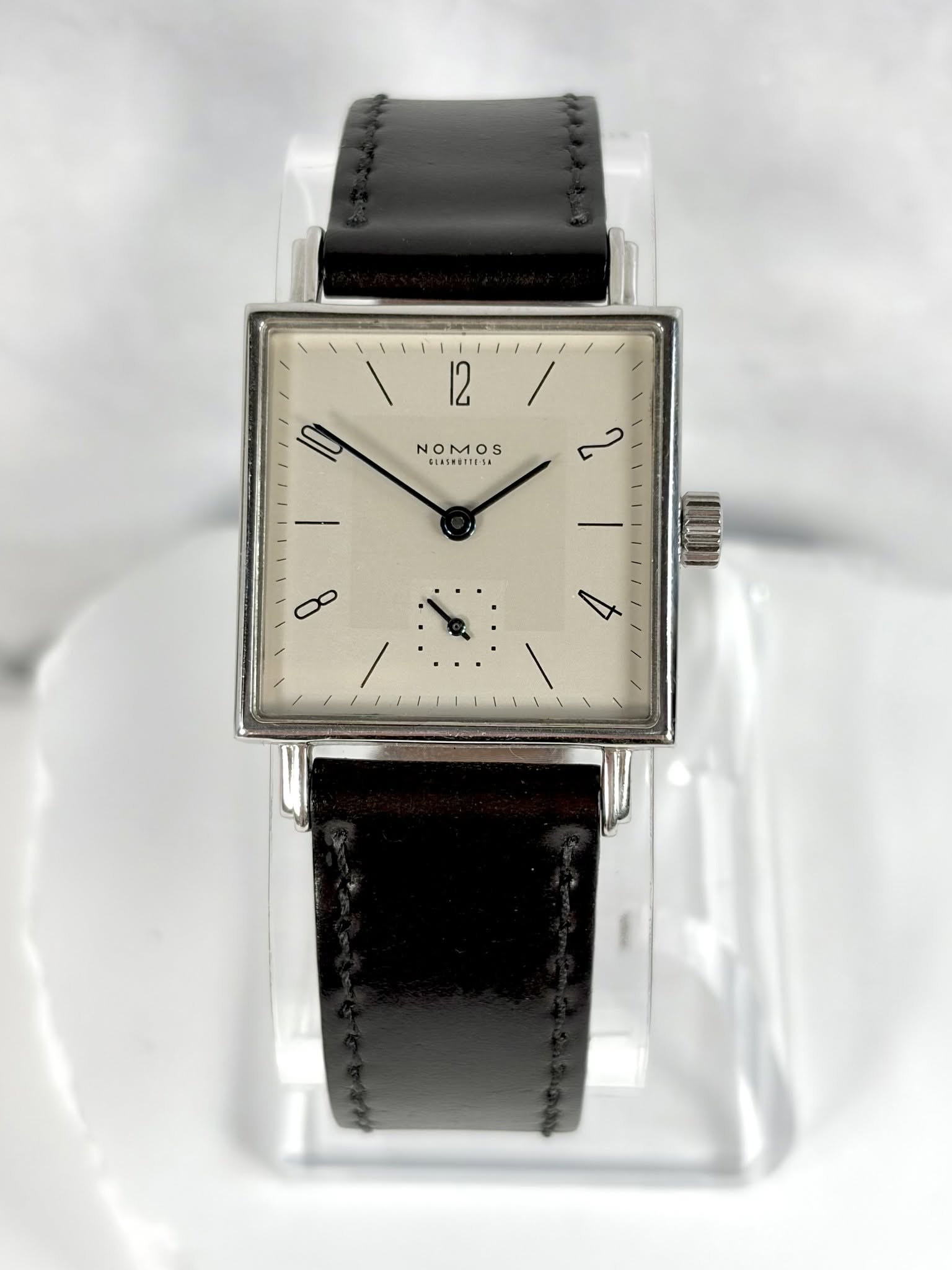 May be an image of wrist watch, leather and text