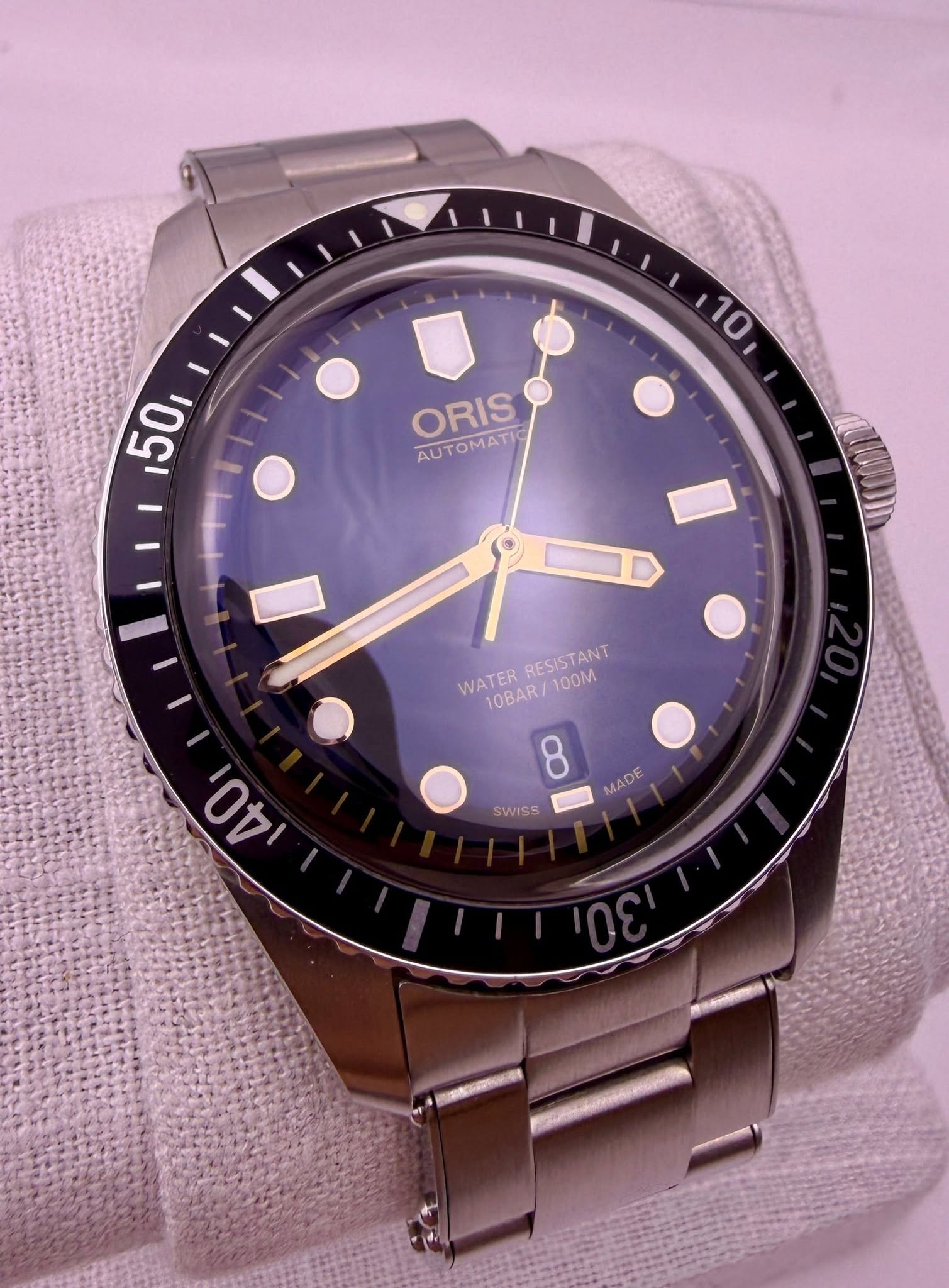 May be an image of wrist watch and text that says ' ORIS AUTOMATIC WATER RESISTANT WATERRESISTANT 10BAR RESIS 100M 8 - Os AO SWISS MADE'