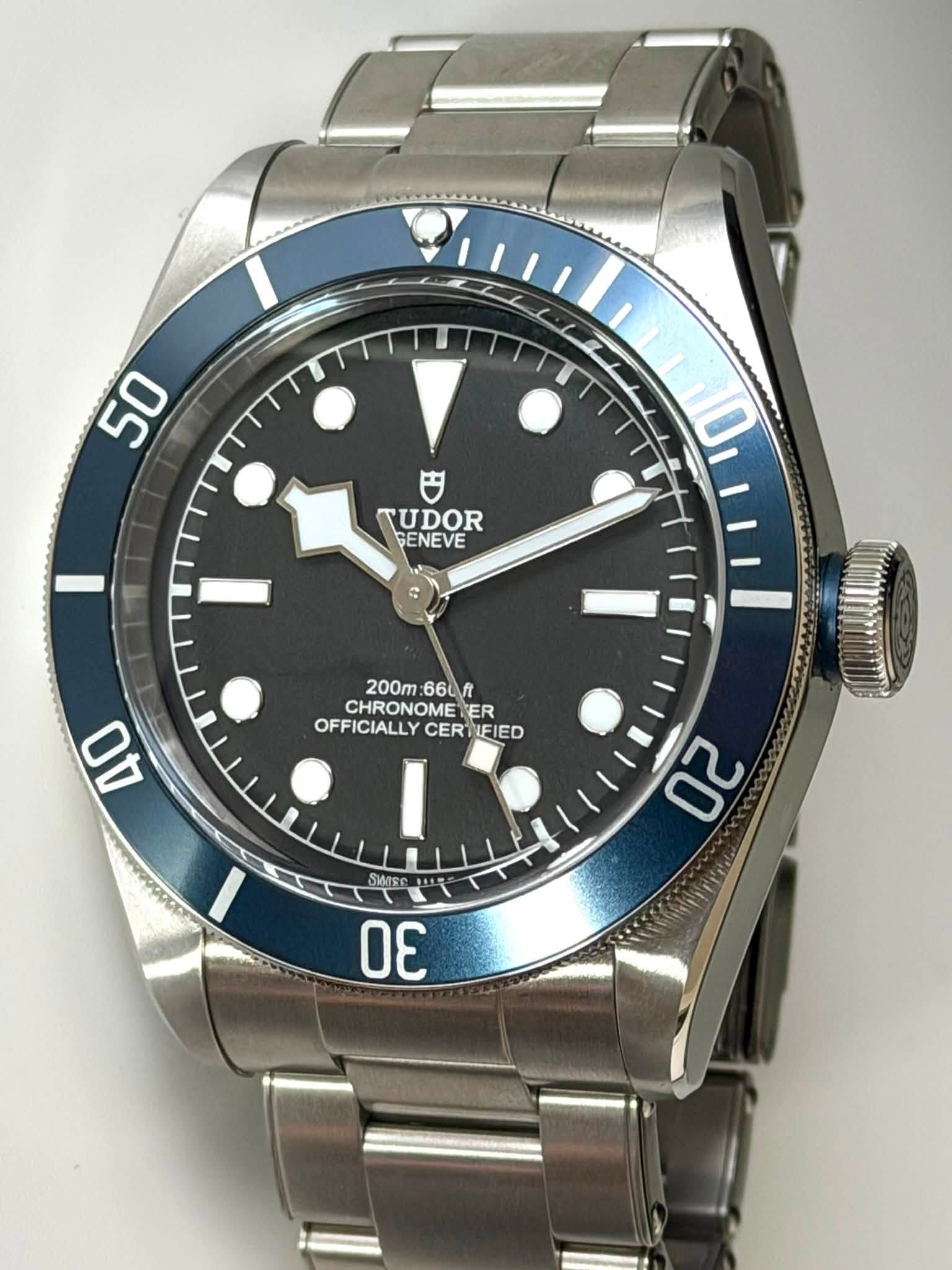 May be an image of wrist watch and text that says '50 0 TUDOR GENEVE E 200m 66Л CHRONOME ER OFFICIALLY OFFICIALLYCERTIFIE CERT ERTIFIED AO 20 WTE ሐባች DE'