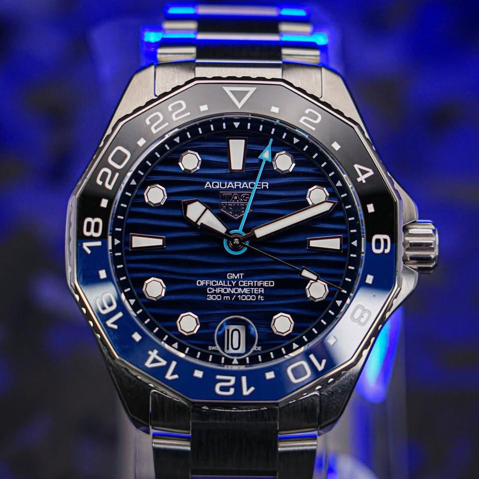 May be an image of text that says ' AQUARACE R 4 18 GMT OFFICIA OFFICIALLYDERTIFIED CERTIFIED CHRO CHRONOMETE CHRONOMETER OMETER OMETER ER CHRONOME 300 /1000 fc 6 16 I 8 ក្នម្ពុជា…