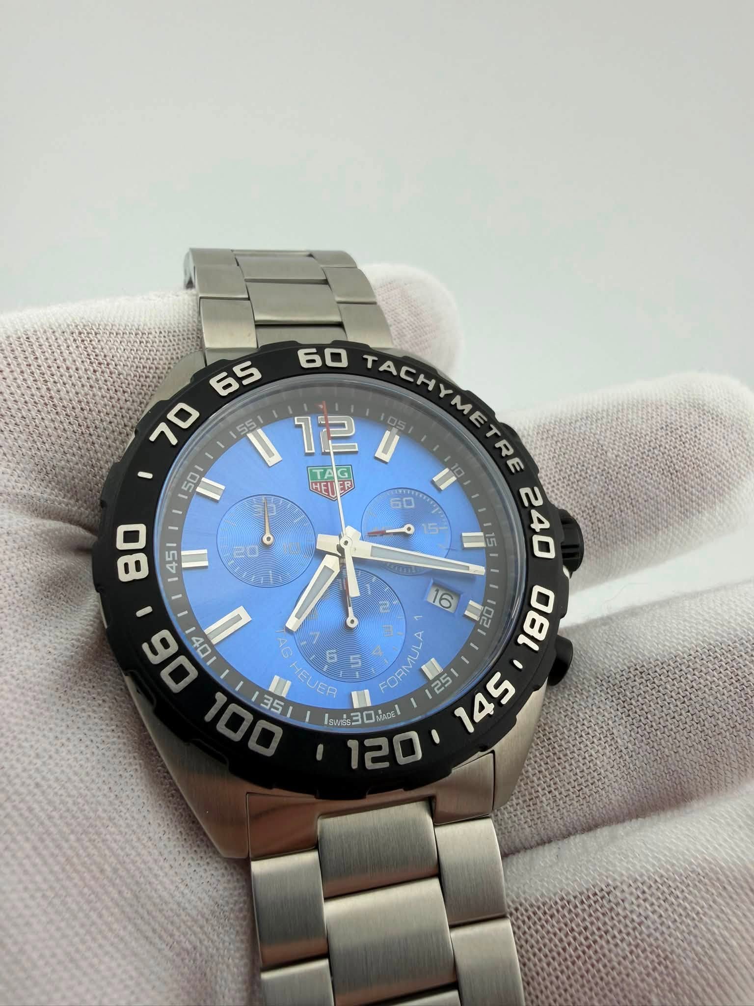 May be an image of wrist watch and text that says ' TACHYMETRE 10 2ן 051 R TA E HEU AG HEUER 6 5 โรพณี30น JAOE 120' '
