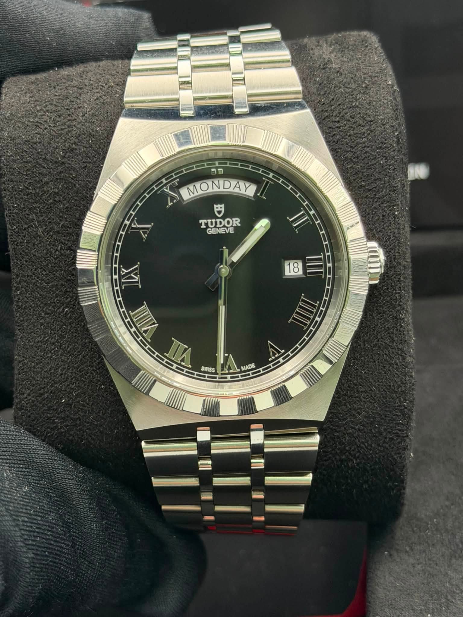 May be an image of wrist watch and text that says 'פר MONDAY 円 TUDOR GENEVE AI II 18 TII IX VIIIIT VIL SUISS ae MADE'