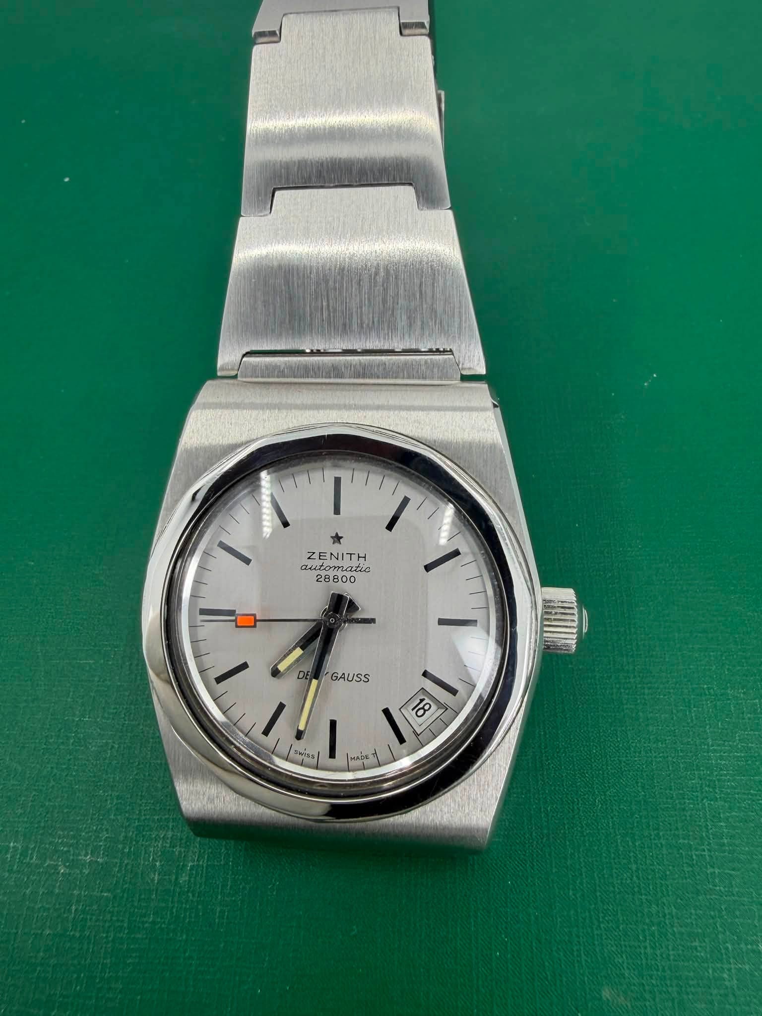 May be an image of wrist watch and text that says 'I' ZENITH automatic SZENITHO γα t أَ MADE GAUSS Saiss'