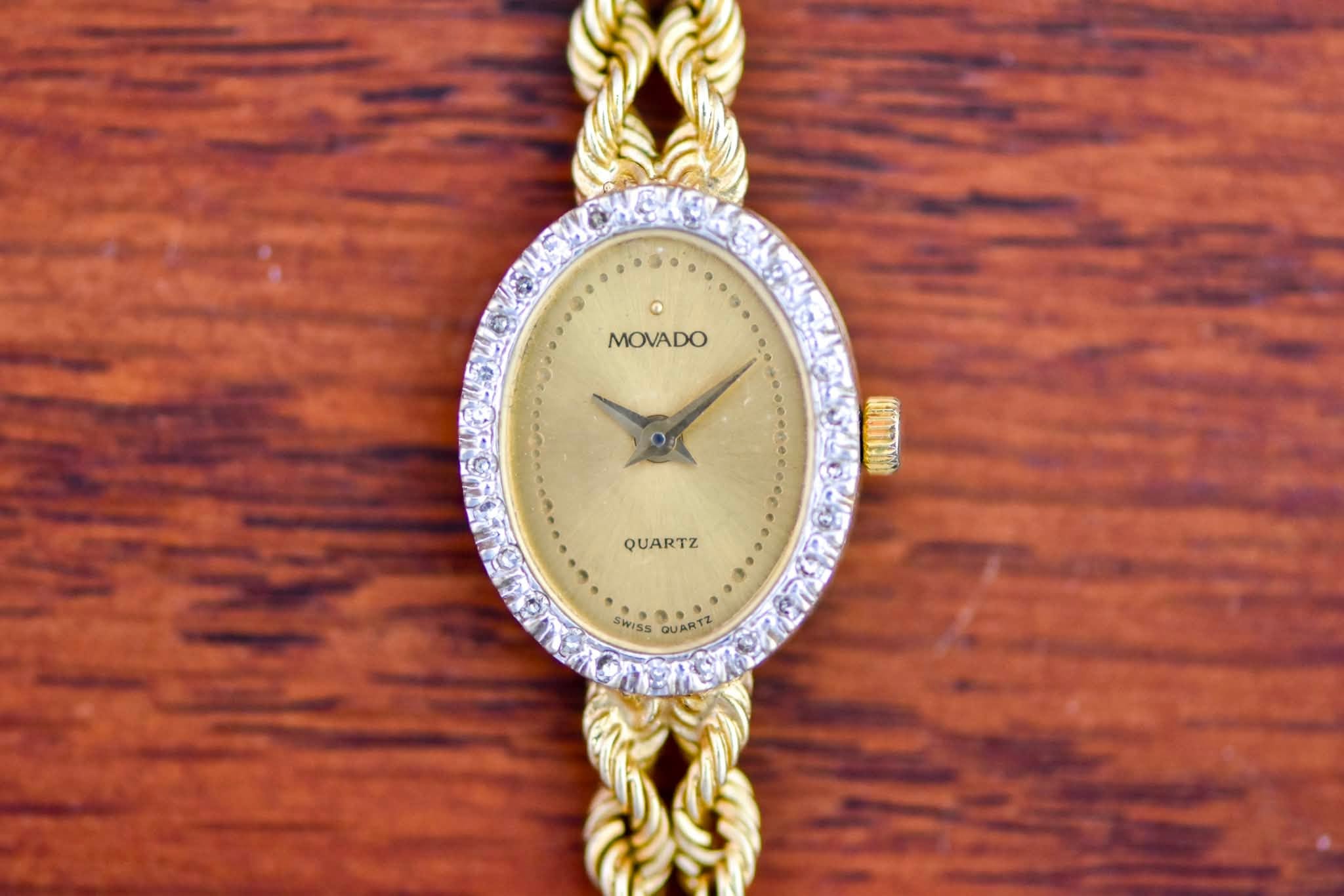 May be an image of jewelry, wrist watch and text that says 'MOVADO MOVADO QUARTZ QUARTZ SWISS RiS QUARTZ'