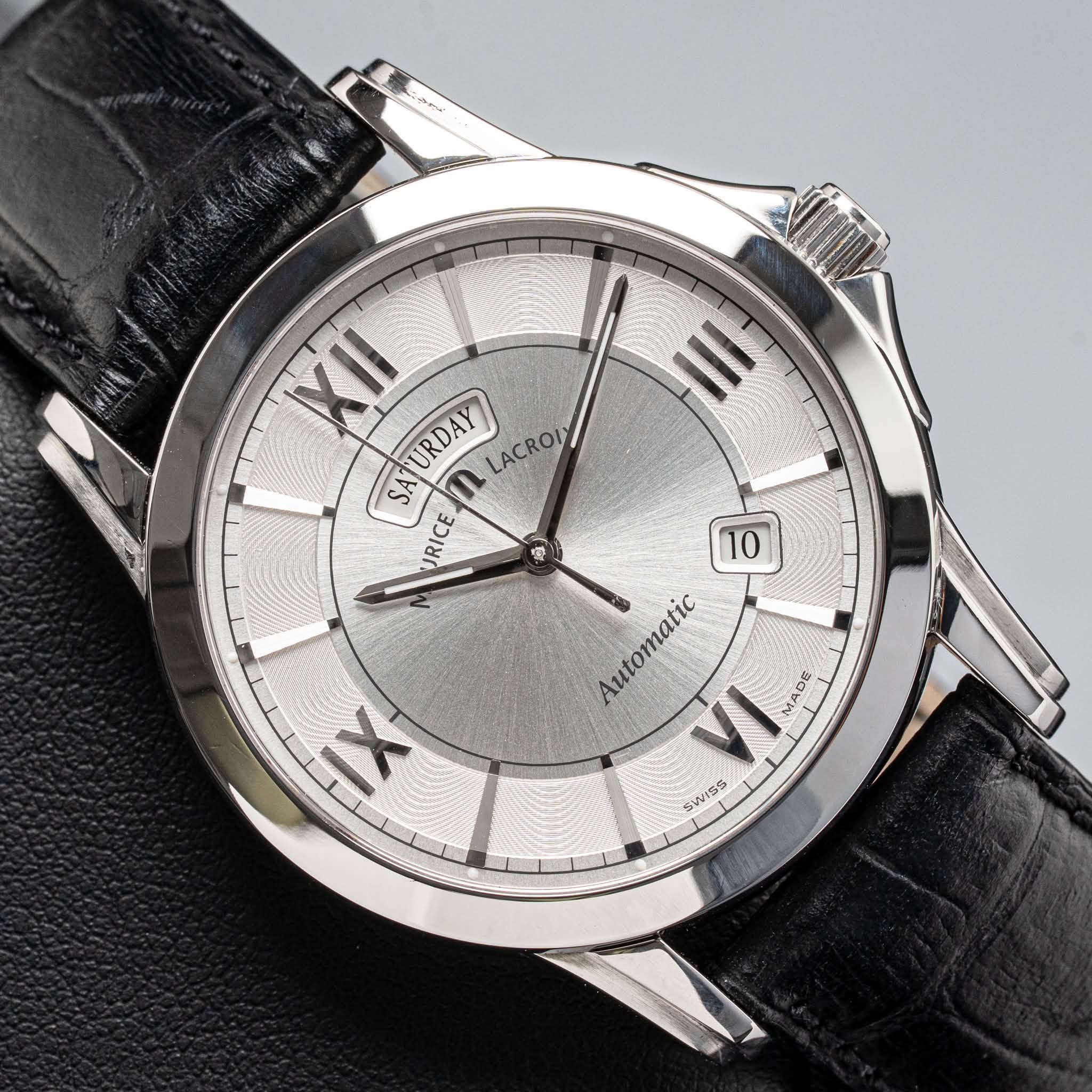 May be an image of wrist watch and text that says 'مe 37 XII URDAY LACROI SA SATURDAY n SA RICE 草 10 Automatic VI MADE SWISS IX'