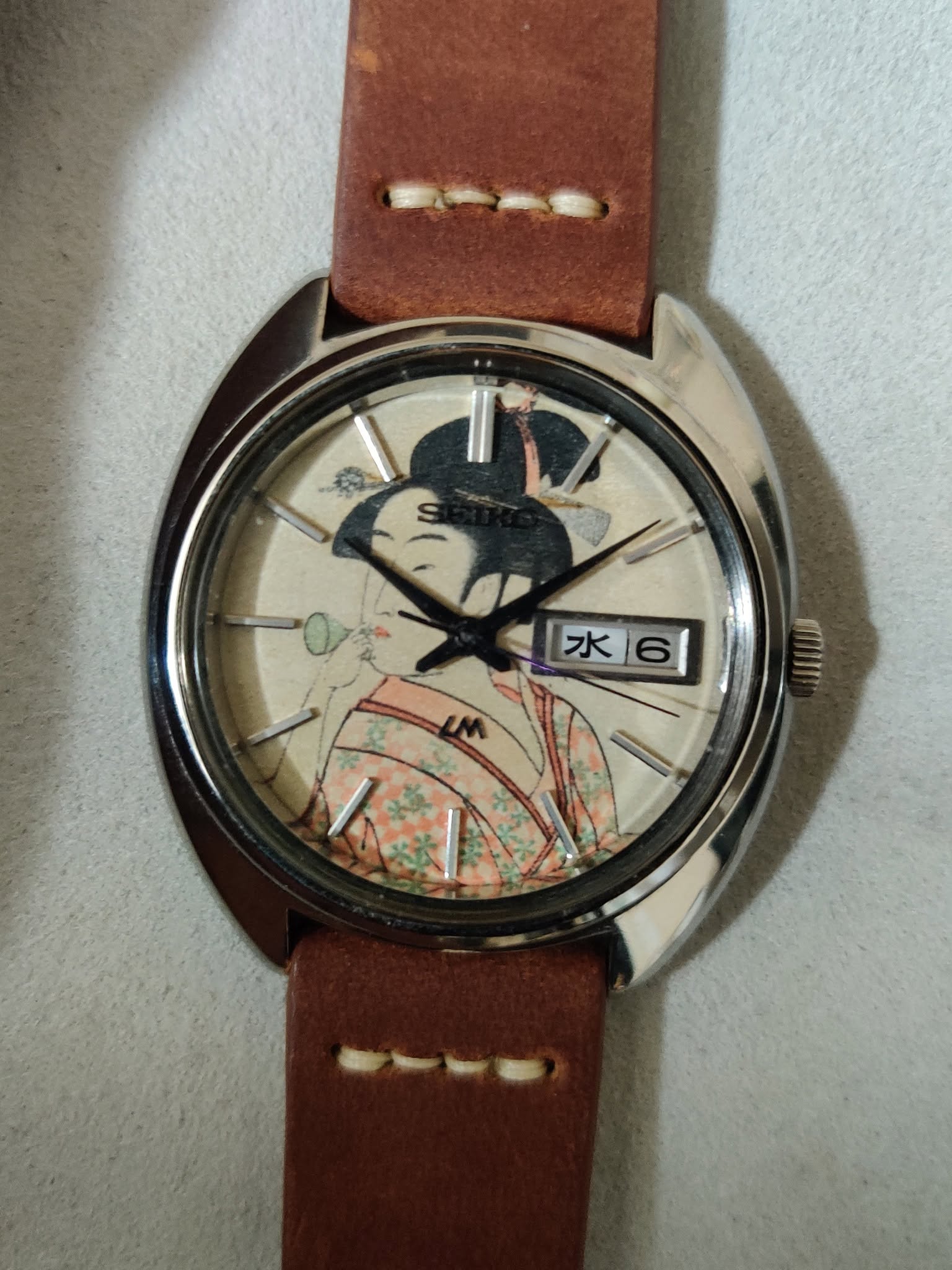 May be an image of leather, wrist watch and text