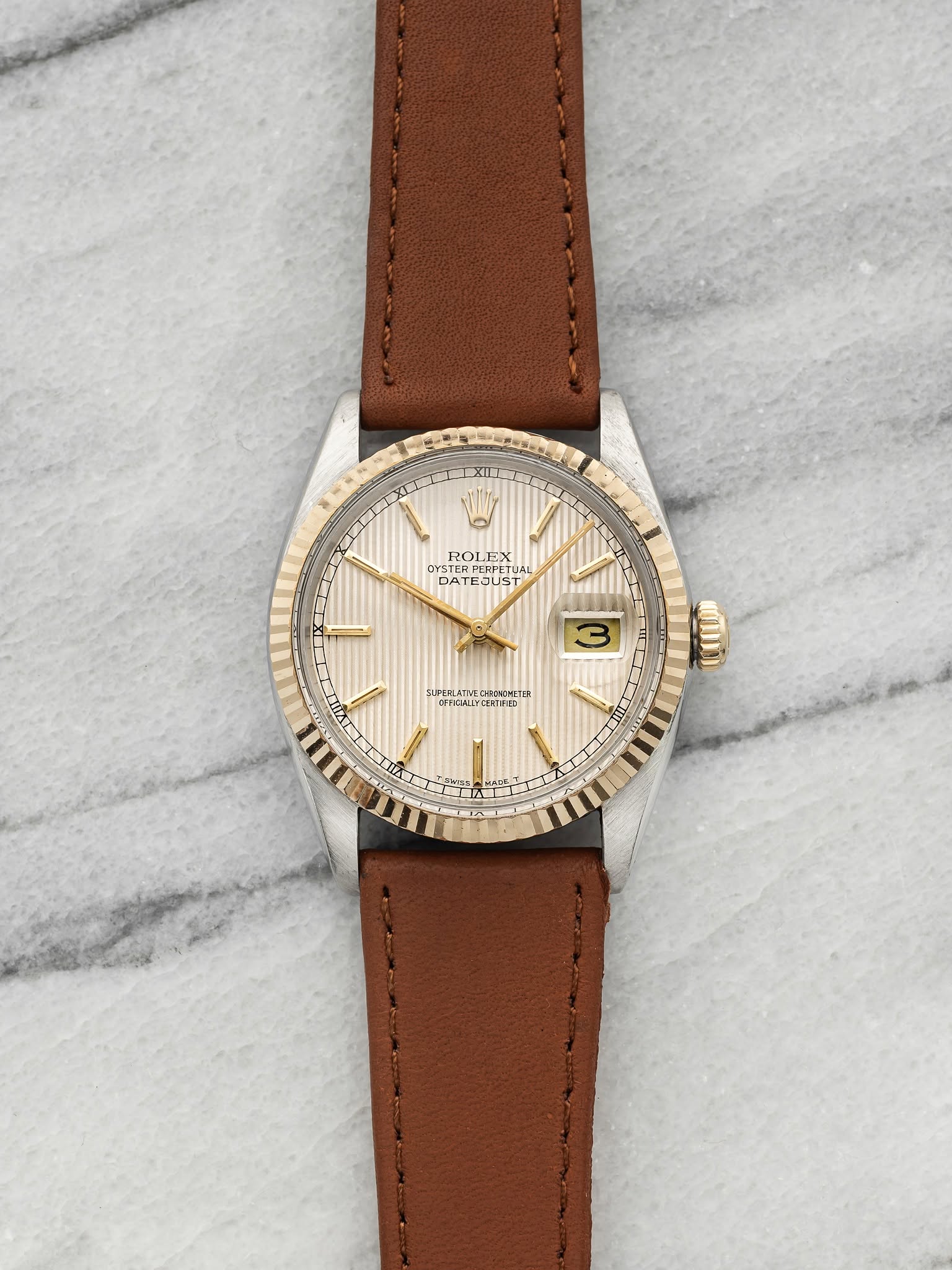 May be an image of wrist watch, leather and text