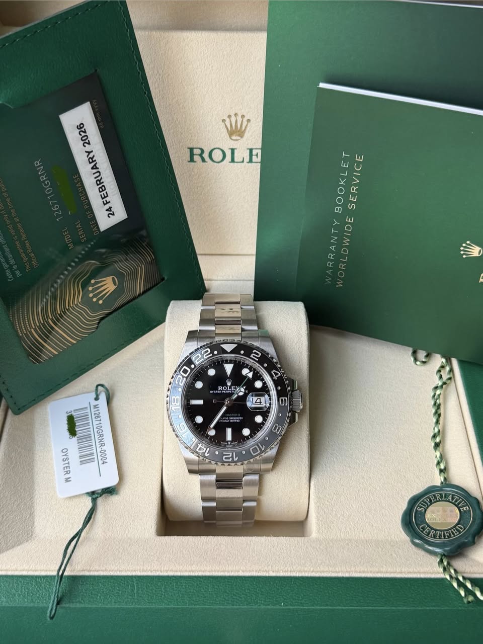May be an image of wrist watch and text that says '2026 FEBRUARY 24 ROLE BOOKLET SERVICE RRANTY DWIDE 2 22 20 ح ROLEX ROLE 14 6 M126710GRNR-0 OYSTERM - SPRFATTE CERTIFIED'