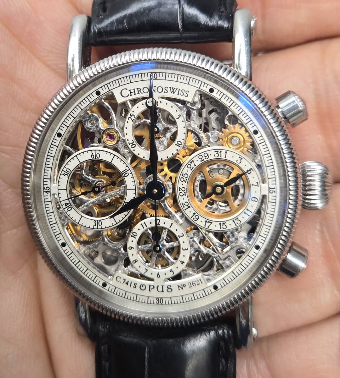 May be an image of wrist watch and text that says 'CHRO SOSWISS 0 T0 AG V C0 18 61 L 0 शी O 6 HP न्ক ٩ 3 8 5 カ 3 6 5 C.741S G PuS C nu ZN 1621 12'
